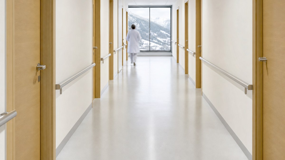 Pasillo luminoso de una clínica moderna, limpio y vacío, con puertas de consulta a los lados
