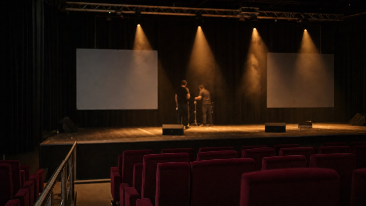 Escenario de una gala con focos, butacas vacías y pantallas apagadas antes de empezar