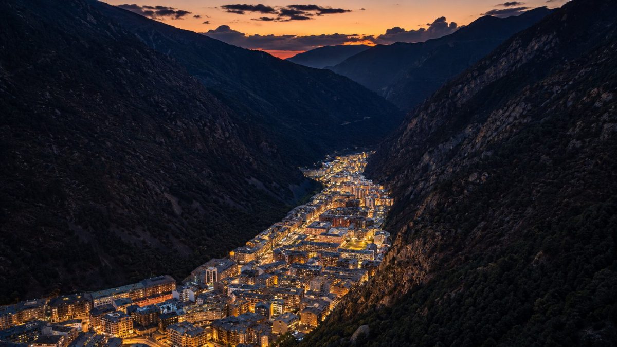 La ciudad de Andorra apretada en el fondo del valle entre montañas al anochecer